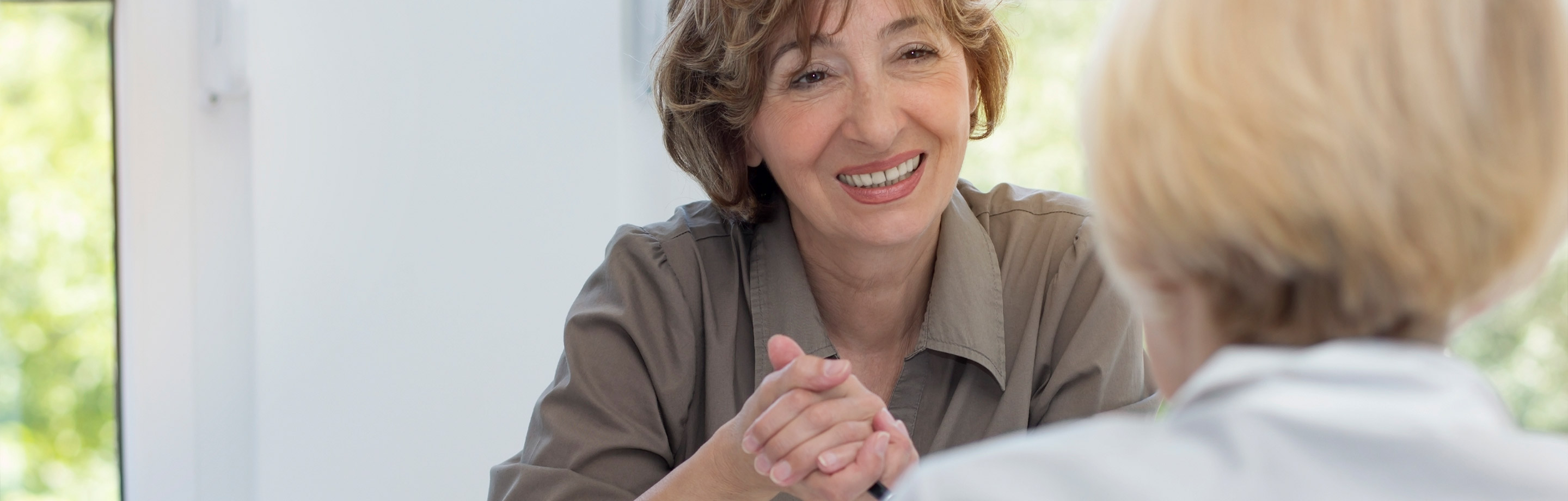 Older woman holding the hand of another woman