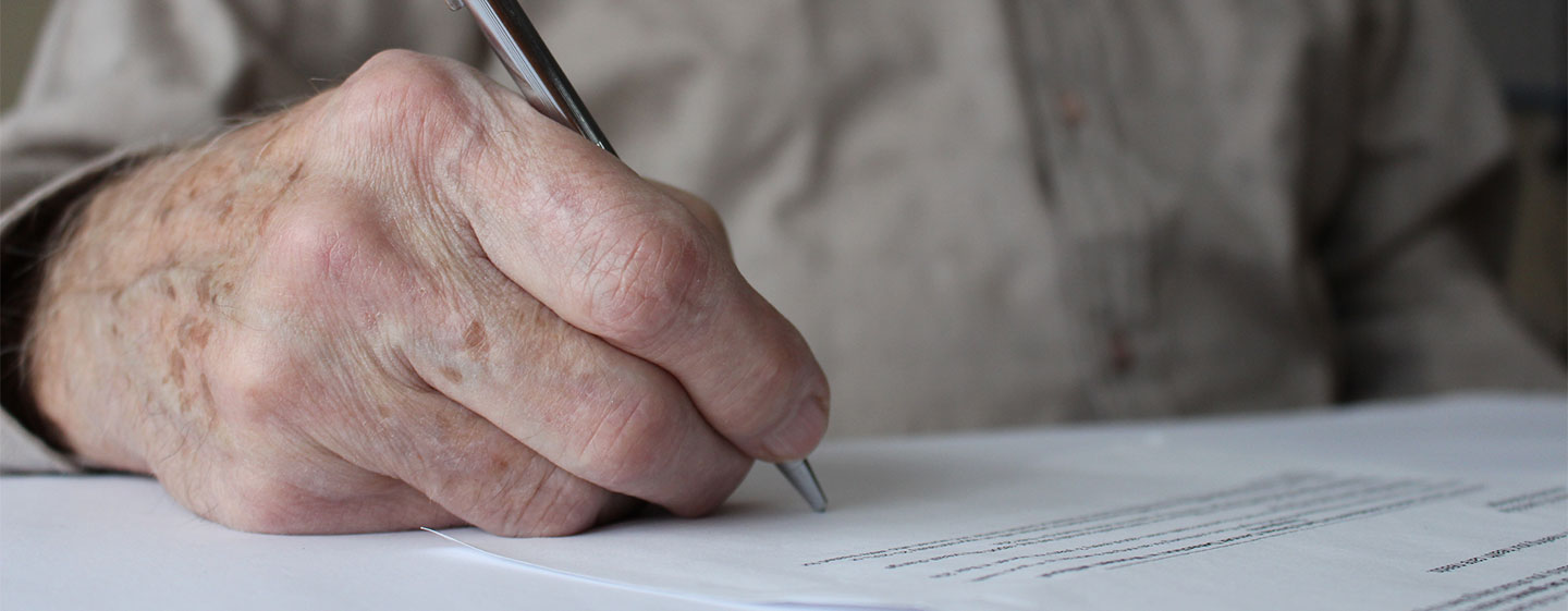 Hand of an older man writing